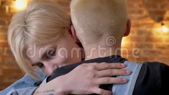 年轻可爱的女孩拥抱他的男朋友时髦的情人砖背景视频的预览图