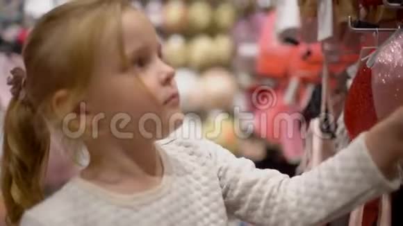 小女孩在超市里挑选衣服快乐的一家人在购物在商场里的家人在商店里买婴儿衣服视频的预览图