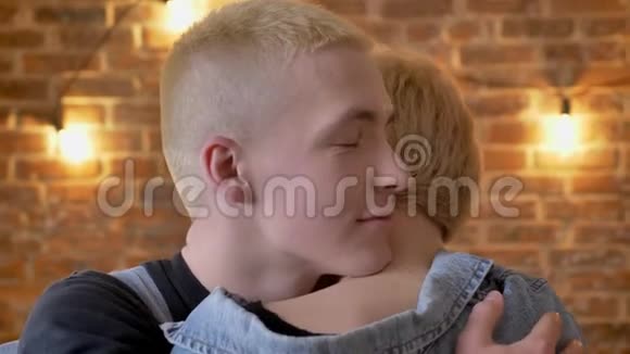 年轻可爱的男孩子hipster拥抱他的女朋友情人砖背景视频的预览图