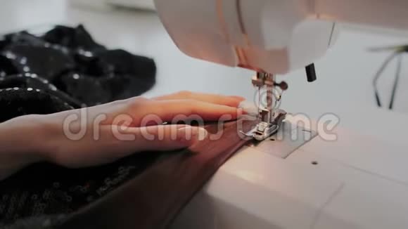 在缝纫机上工作的女性手的特写镜头在家里或车间使用缝纫机的年轻妇女视频的预览图