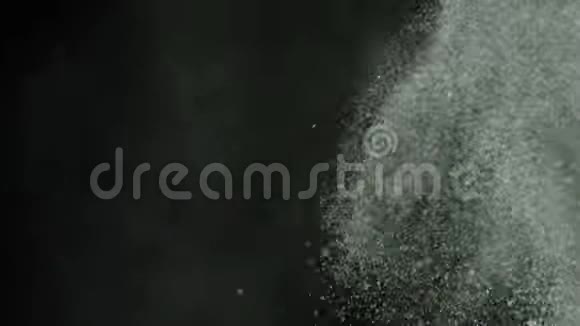在黑色背景上喷洒灰尘库存录像用喷气机吹去厚厚的白色灰尘视频的预览图