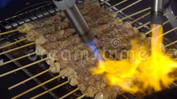 厨师烤牛肉或牛排在街边食物的烤架上插入烟雾和火焰视频的预览图