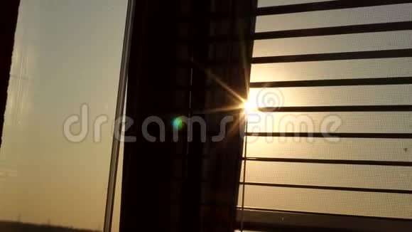 窗后日出百叶窗和蚊帐窗户百叶窗后面的太阳视频的预览图
