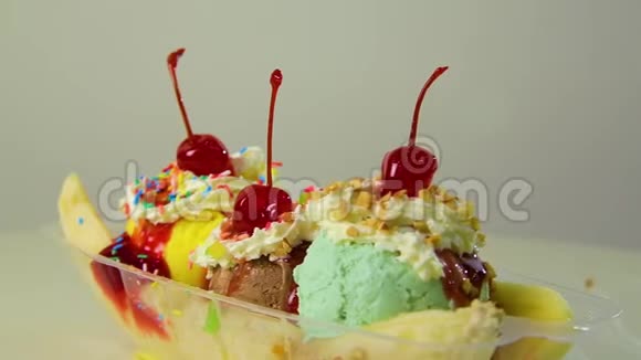 香蕉船上摆放着带有樱桃馅坚果奶油和樱桃浆果的鲜嫩多汁的冰淇淋球视频的预览图