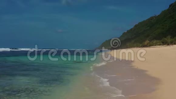 巴厘岛南部海岸带金色沙滩和绿松石波浪水的里亚尔景观视频的预览图