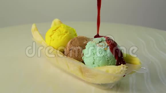 特写多汁的彩色冰淇淋球上面浇着甜樱桃视频的预览图