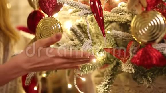 带着圣诞老人的年轻女子触摸装饰圣诞树的树枝视频的预览图