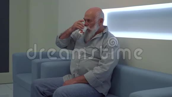 老人坐在诊所的沙发上等待轮到他视频的预览图