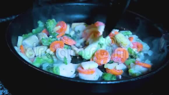 在锅上搅拌的冷冻蔬菜混合物视频的预览图
