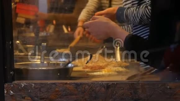 厨师手在快餐店准备煎蛋卷煎饼面条等美味菜肴妇女和男子的侧视视频的预览图
