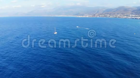 希腊克里特岛蓝色海洋和白色小游艇的空中全景视频的预览图