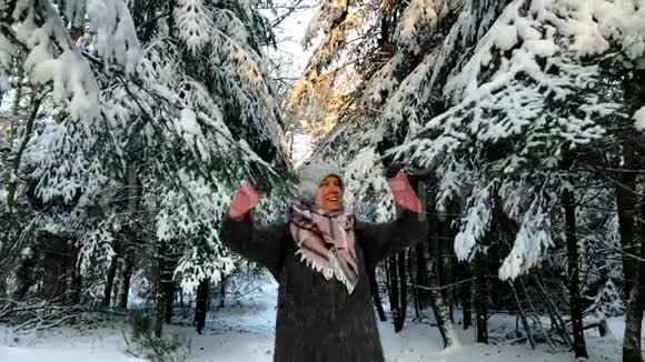 一位年轻女子穿过白雪皑皑的森林视频的预览图