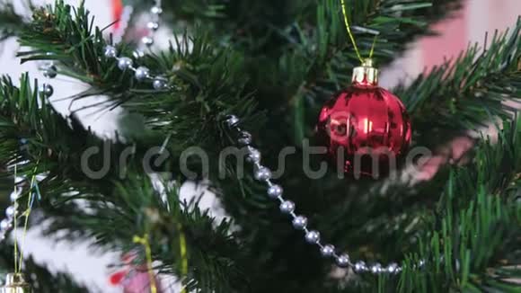 在圣诞树的树枝上旋转着红光闪闪的球视频的预览图