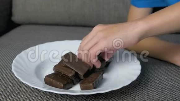 男孩的手在沙发上的白板上搭了一座巧克力糖塔视频的预览图
