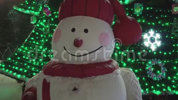 圣诞树背景上有趣的雪人夜晚时间特写视频的预览图