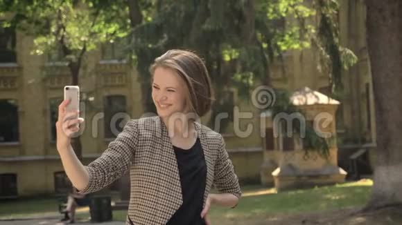 年轻迷人的女孩白天在公园里自拍夏天摸头发交流观念视频的预览图