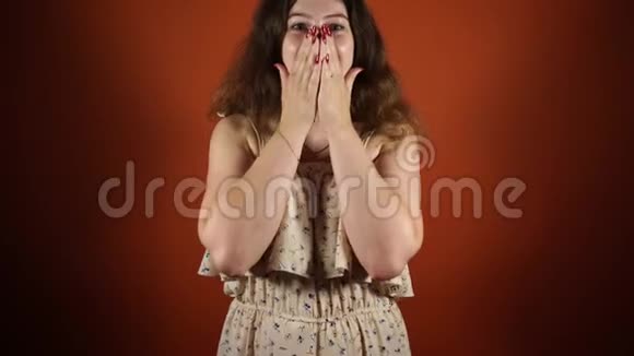 快乐的女人站在橙色的背景上快乐的女人视频的预览图