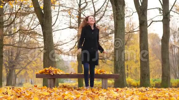 秋天公园里无忧无虑的女人跳舞扔树叶视频的预览图