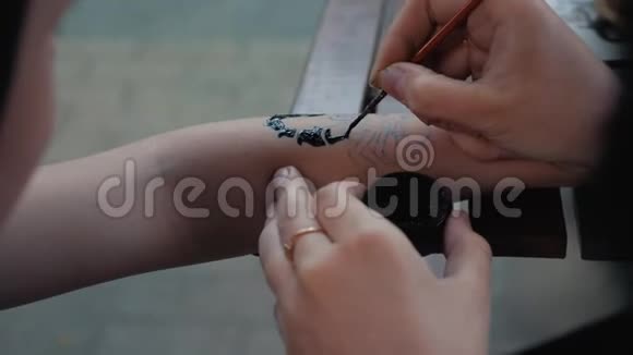 画一个孩子他手上的纹身用黑色油漆孩子们的手上画着美丽画视频的预览图