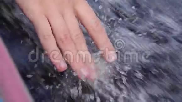 女性用手指触摸起泡的水同时漂浮在发动机船上关门视频的预览图