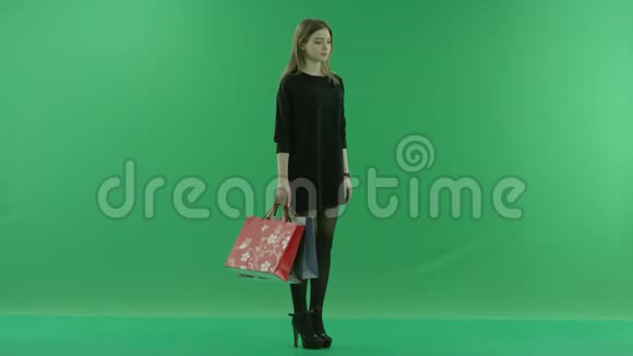 带购物袋和手表的年轻女性彩色钥匙绿色背景视频的预览图