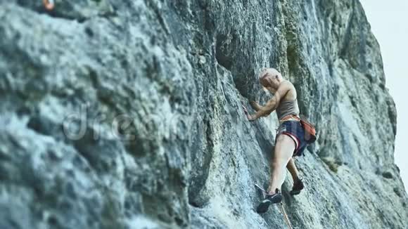有彩色头发的运动妇女在山上攀岩视频的预览图