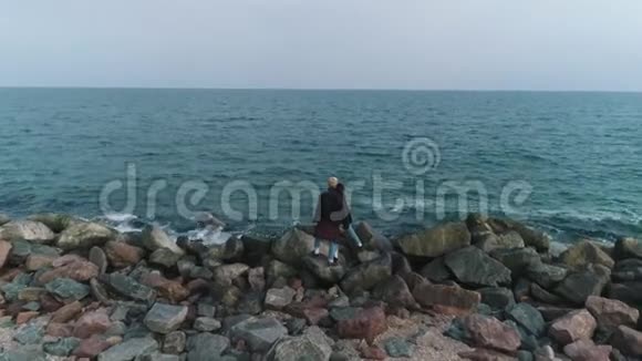 一对夫妇在海边的石滩上视频的预览图