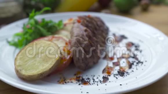 将烤好的肉排和炸土豆贴在白色盘子上食物组成肉片烧烤与蔬菜装饰视频的预览图