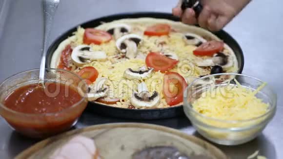 厨师准备披萨把橄榄放进去视频的预览图
