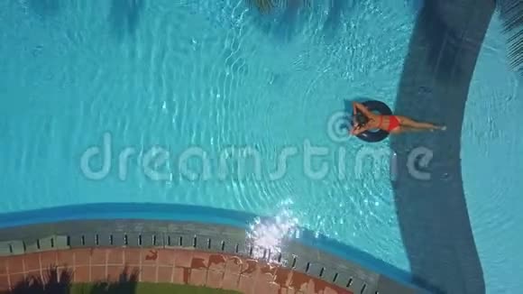 酒店椭圆形游泳池配有折叠椅和女士水视频的预览图