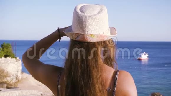 海岸上的女孩环视蔚蓝的大海视频的预览图