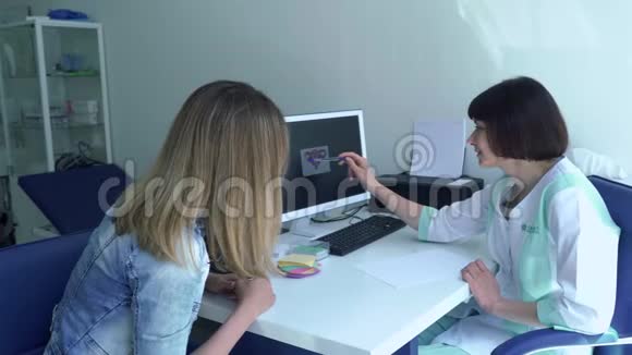 妇科医生向病人解释她的子宫是如何在电脑上显示照片的视频的预览图