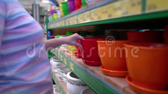 白人妇女在商店货架附近选择陶瓷锅为家庭在商店特写视频的预览图