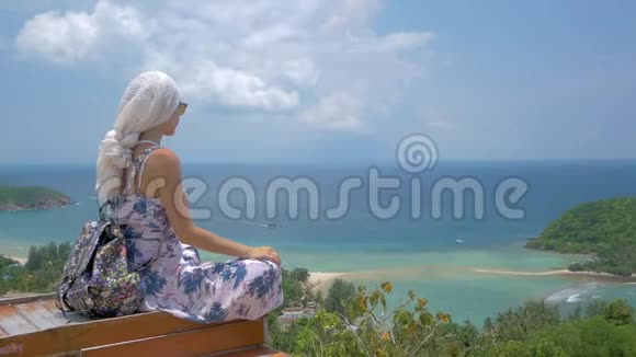 3乘1年轻女子坐在美丽的海湾景观视频的预览图