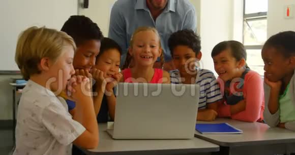 成人白种人男性教师在4k教室用笔记本电脑教孩子视频的预览图