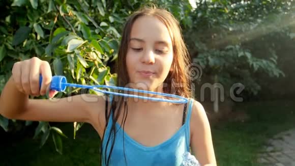公园里美丽少女吹肥皂泡的慢动作视频视频的预览图