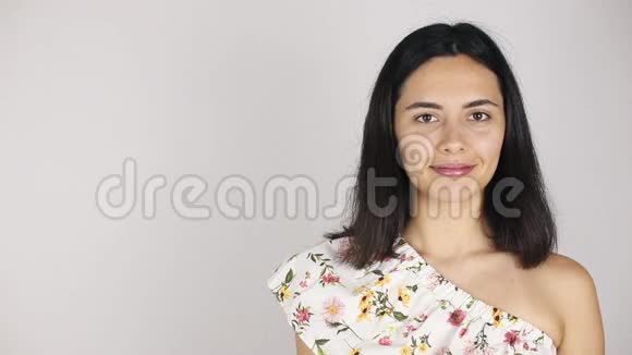 女孩脸上贴着一束花一个年轻漂亮的女人嗅着灰色花束的肖像视频的预览图