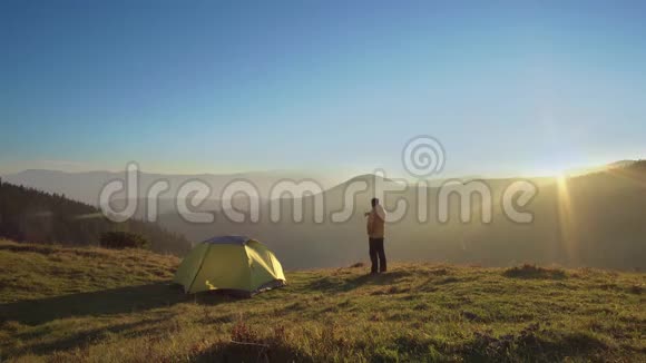一个人站在山上的帐篷附近视频的预览图