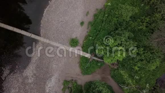 森林中通过河流的桥梁的俯视图库存录像悬着的木桥穿过宽阔的河流视频的预览图