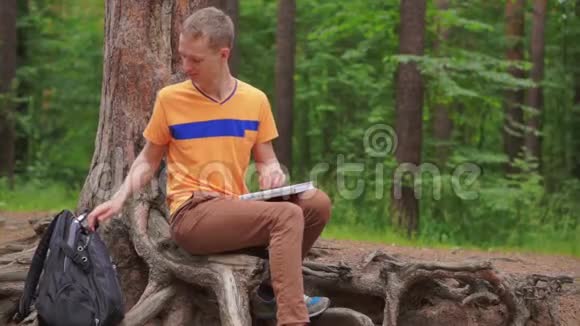森林里的一个年轻人读一本训练书视频的预览图