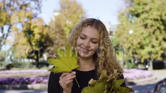 一公园里站着一个枫叶的年轻女子视频的预览图