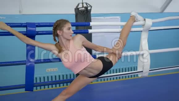 伸展运动有灵活腿的女性在体育中心的比赛前在体操锻炼中做麻绳动作视频的预览图