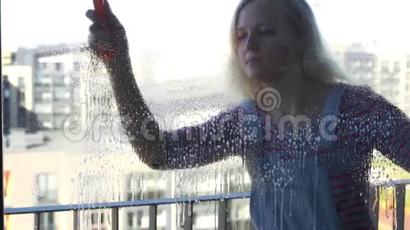 年轻女子擦窗动作缓慢视频的预览图