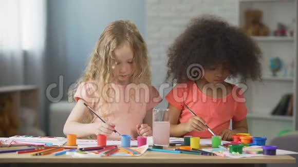 白人和非裔美国女孩在艺术学校画画闲暇时间视频的预览图