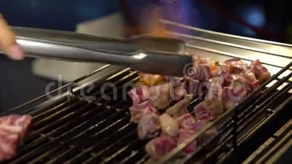 4k小贩在夜市的烤架上用喷灯烹制牛肉肉片视频的预览图