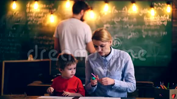 这个男孩和老师在教室里画画学习观念穿制服的学童教室里的老师视频的预览图