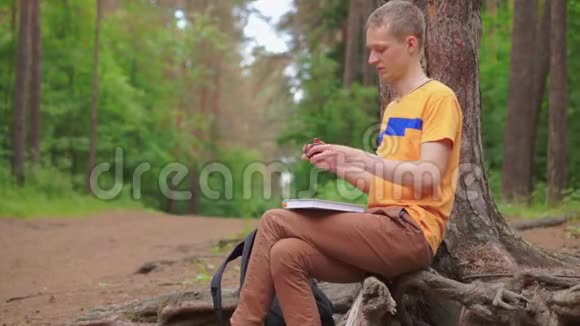 一个年轻人戴上耳机一边听音乐一边读一本书视频的预览图
