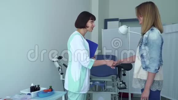 妇科医生问候年轻女子邀请她坐妇科椅视频的预览图