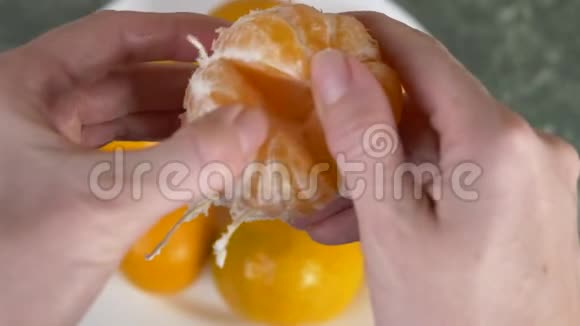 女人手剥山皮柑片堆在碗里4k慢动作视频的预览图