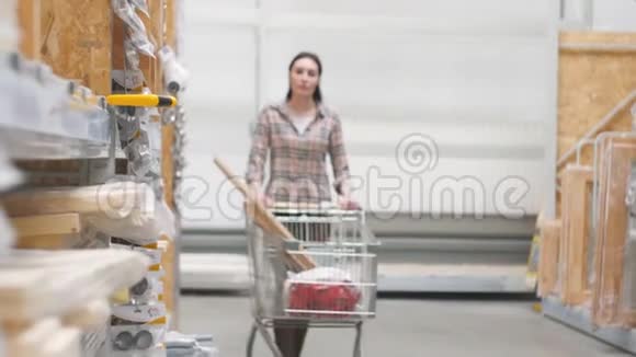 25岁的女孩在一家带着手推车的五金店买锯子视频的预览图